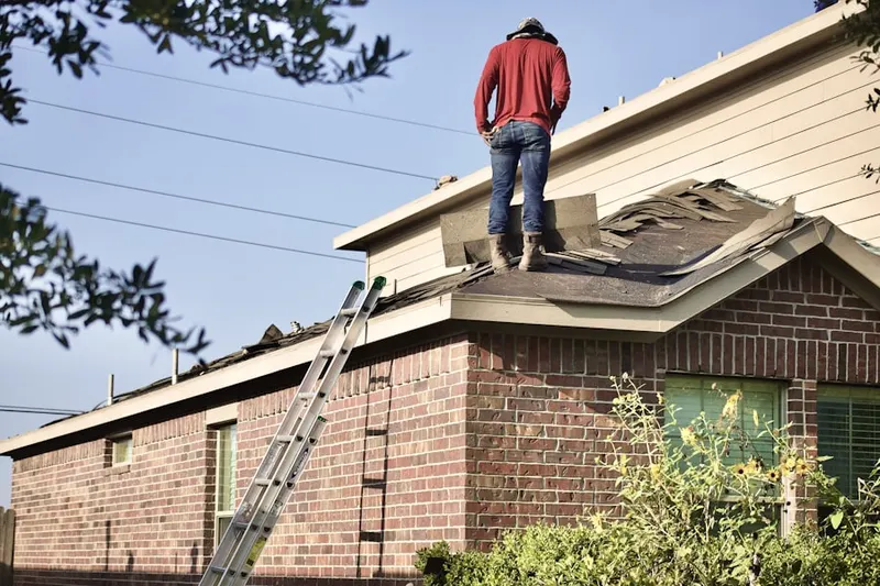 Professional roofer working on a residential roof in Schroeppel